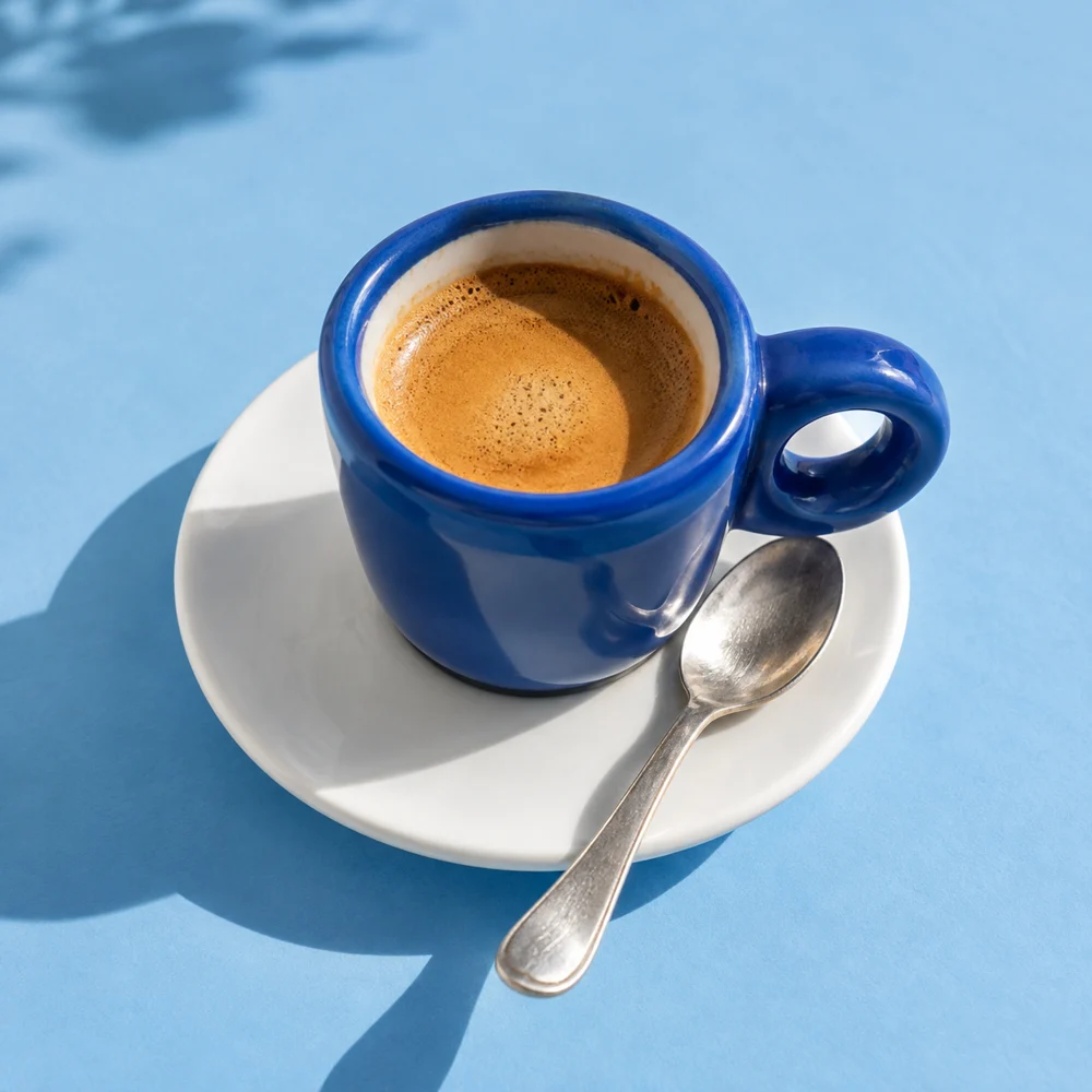 A blue espresso cup in the morning sunshine